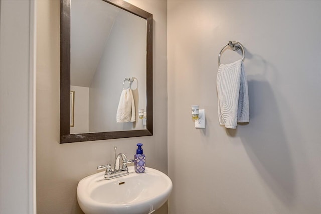 bathroom with vaulted ceiling and a sink