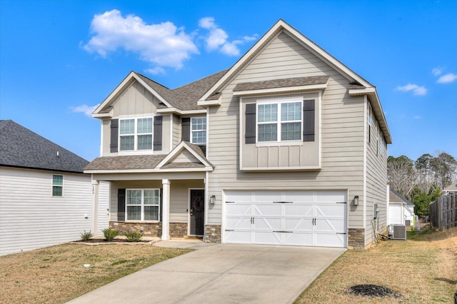 view of front of house featuring stone siding, an attached garage, board and batten siding, and driveway