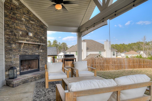 view of patio / terrace featuring an outdoor living space with a fireplace, area for grilling, a ceiling fan, and fence