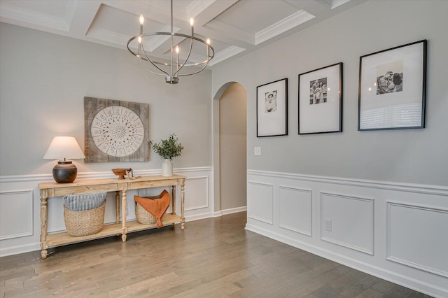 interior space with beam ceiling, a notable chandelier, wood finished floors, and arched walkways