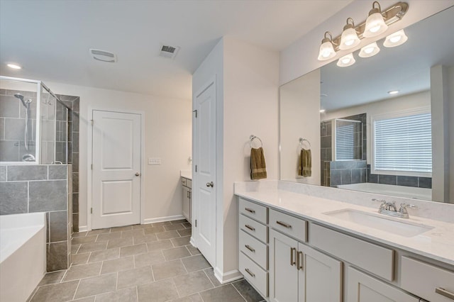 bathroom with vanity, a garden tub, and a shower stall