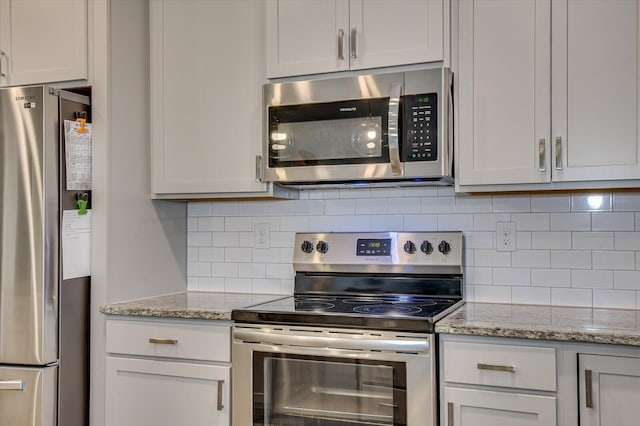 kitchen featuring light stone countertops, tasteful backsplash, and appliances with stainless steel finishes