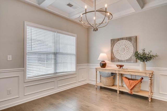 sitting room with beam ceiling, a notable chandelier, wood finished floors, and visible vents