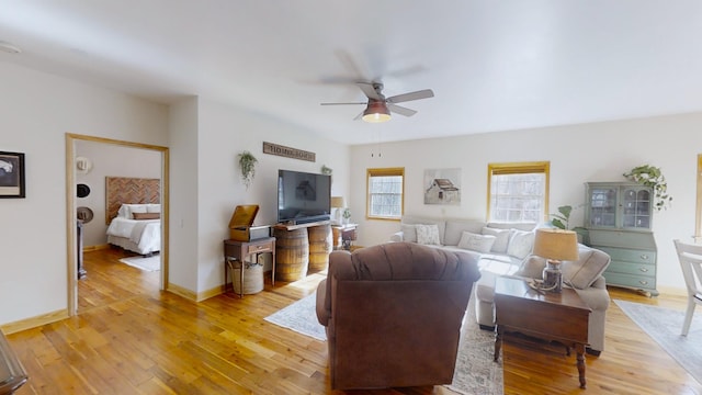 living room with light hardwood / wood-style floors and ceiling fan