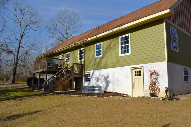 back of house featuring a wooden deck and a lawn