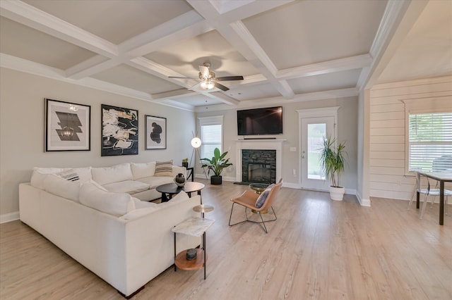 living room with healthy amount of natural light, a fireplace, beamed ceiling, baseboards, and light wood-style flooring