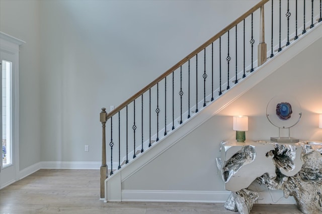 staircase with wood finished floors and baseboards