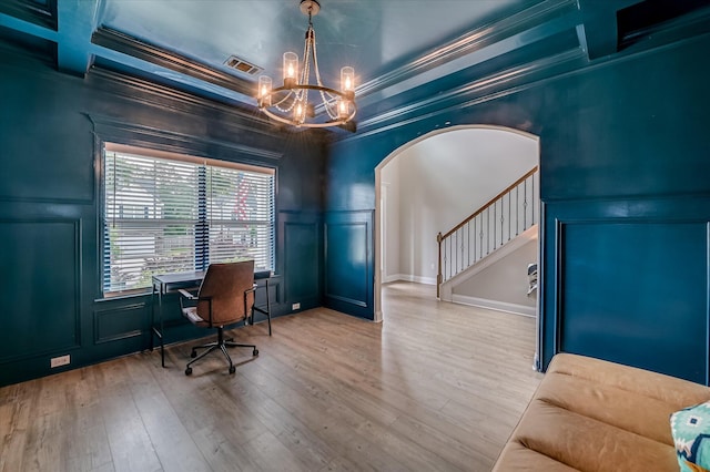 office featuring a decorative wall, a chandelier, crown molding, wood finished floors, and arched walkways