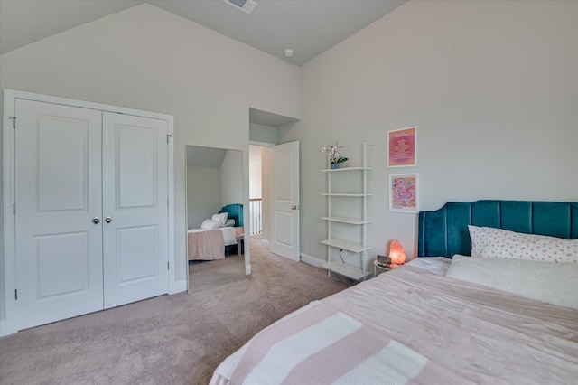carpeted bedroom with high vaulted ceiling, a closet, and baseboards