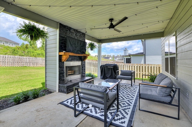 view of patio / terrace with an outdoor living space with a fireplace and ceiling fan