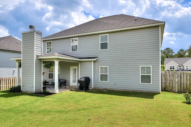 back of property featuring a patio area, a chimney, and a shingled roof
