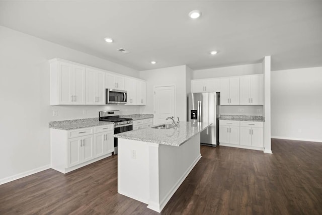 kitchen with white cabinets, sink, stainless steel appliances, and a kitchen island with sink