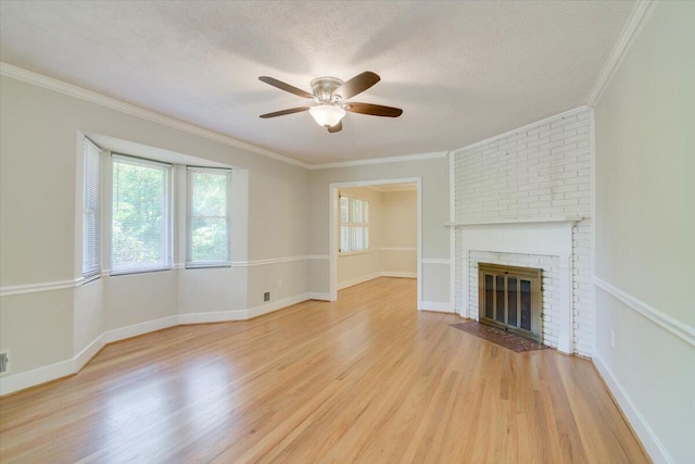 427 Ashland Dr, Augusta, GA 30909 - unfurnished living room featuring healthy amount of natural light, light wood finished floors, a ceiling fan, a fireplace, and crown molding