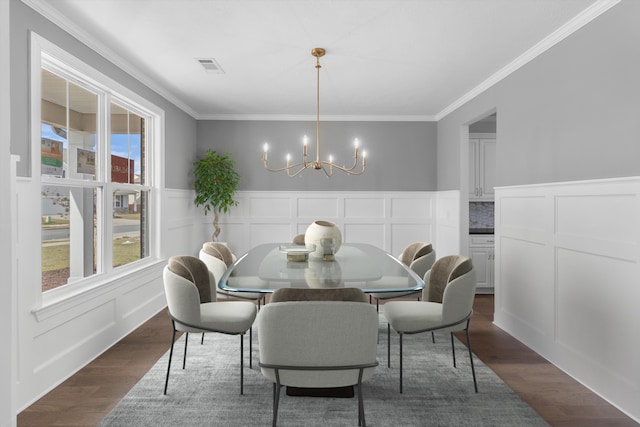 dining space featuring a decorative wall, dark wood finished floors, a notable chandelier, and visible vents