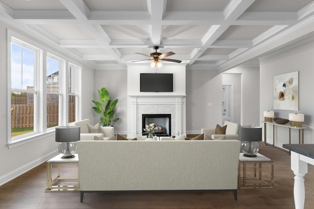 living area with baseboards, ceiling fan, dark wood finished floors, beamed ceiling, and a fireplace