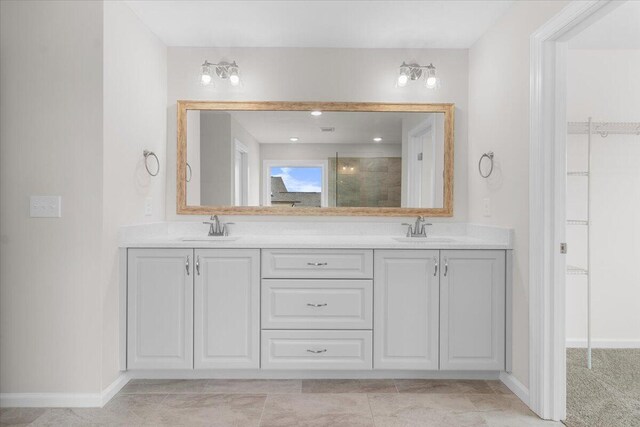 bathroom with double vanity, a stall shower, and a sink