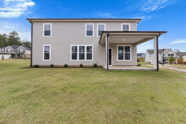 back of property with a patio area, a residential view, and a yard