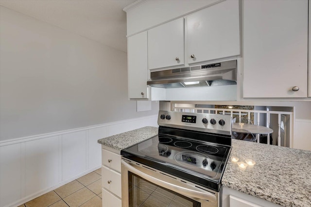 kitchen featuring white cabinets, light tile patterned floors, light stone countertops, and stainless steel electric stove