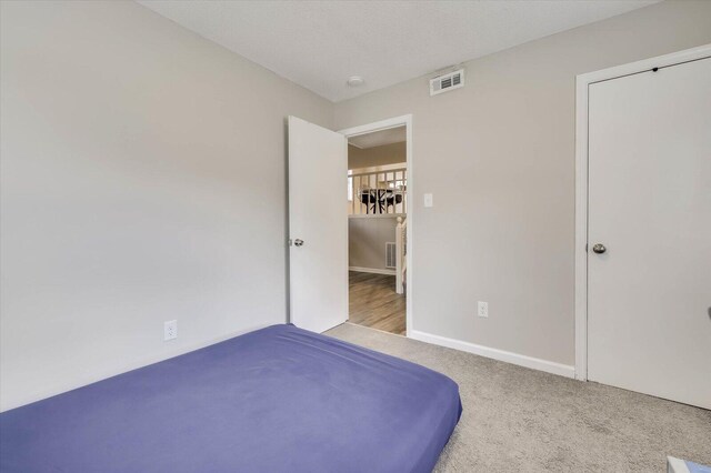 unfurnished bedroom featuring light colored carpet and a textured ceiling