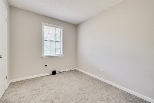 carpeted spare room featuring a textured ceiling