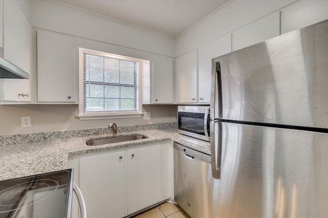 kitchen with light stone counters, stainless steel appliances, sink, light tile patterned floors, and white cabinets