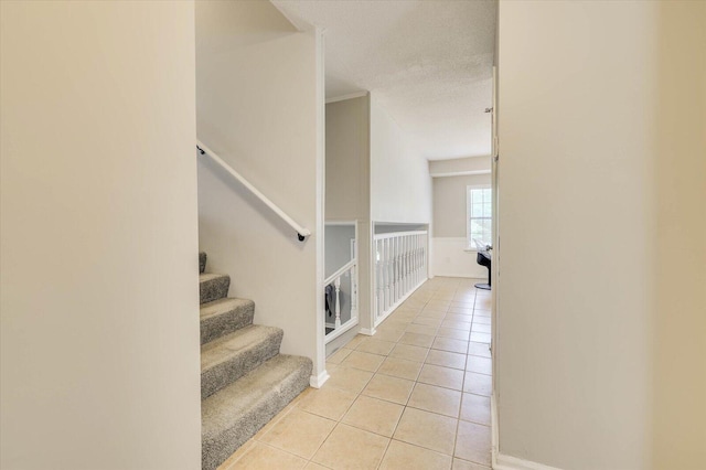 stairs with tile patterned floors and a textured ceiling