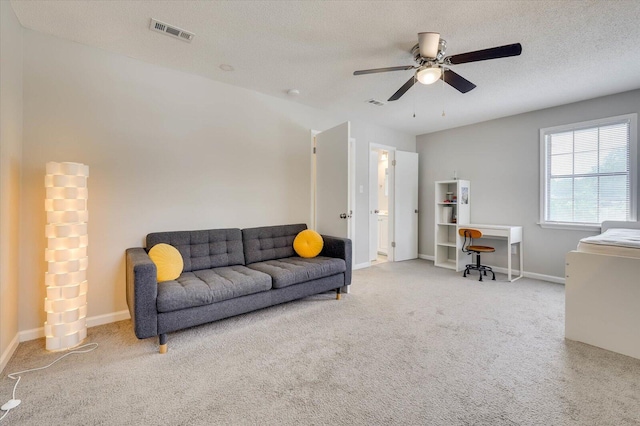 carpeted living room with a textured ceiling and ceiling fan