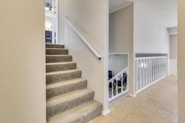 stairs with tile patterned floors, ceiling fan, and a textured ceiling