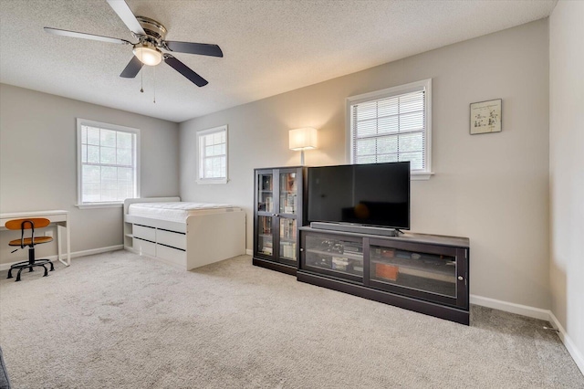 carpeted bedroom with multiple windows, ceiling fan, and a textured ceiling