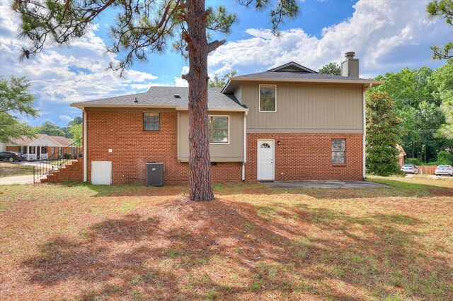 back of property featuring a lawn and central AC unit