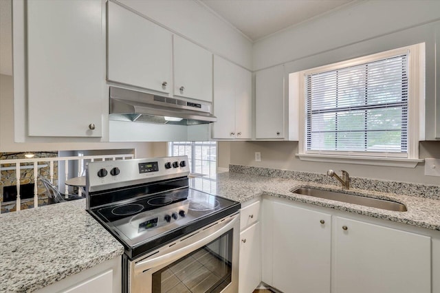 kitchen with stainless steel electric stove, light stone counters, sink, and white cabinets