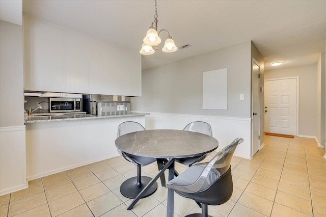 dining room featuring light tile patterned floors, sink, and a chandelier