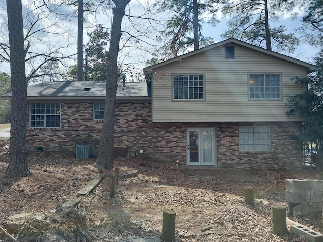 back of house featuring a patio area, central AC unit, and brick siding