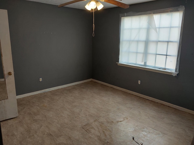 unfurnished room featuring baseboards and ceiling fan