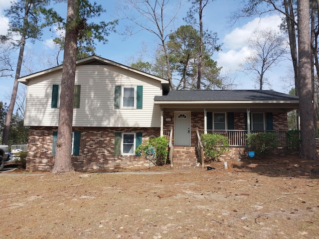 split level home with brick siding and covered porch