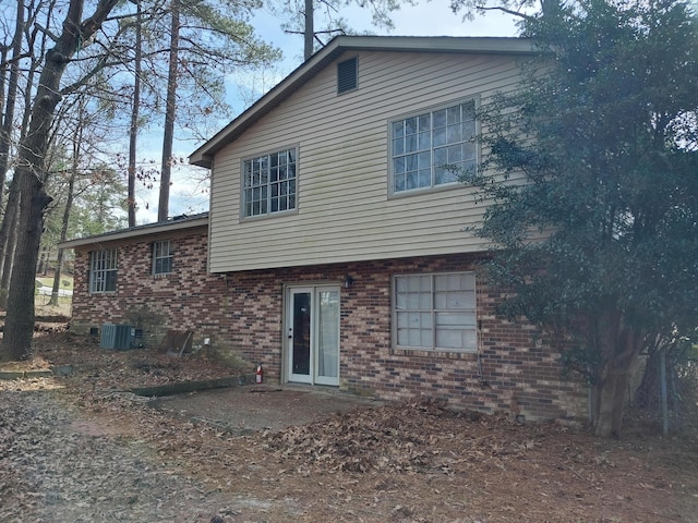 back of property featuring central air condition unit and brick siding