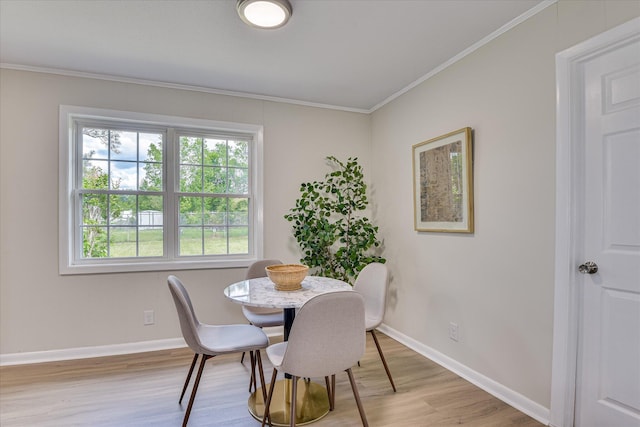 dining room featuring baseboards, ornamental molding, and light wood-style flooring