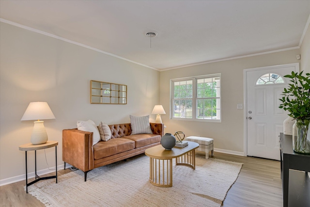 living area featuring light wood-type flooring, crown molding, baseboards, and plenty of natural light