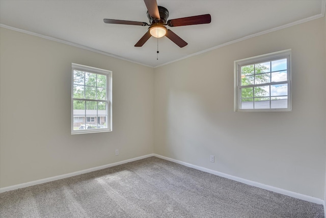 carpeted empty room featuring crown molding, baseboards, and a ceiling fan