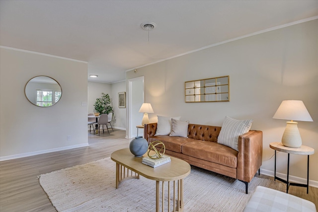 living room featuring crown molding, baseboards, and wood finished floors