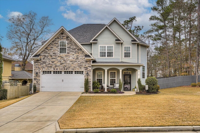 view of front facade with a front yard, a porch, and a garage