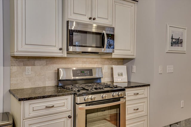 kitchen featuring tasteful backsplash, appliances with stainless steel finishes, and dark stone counters