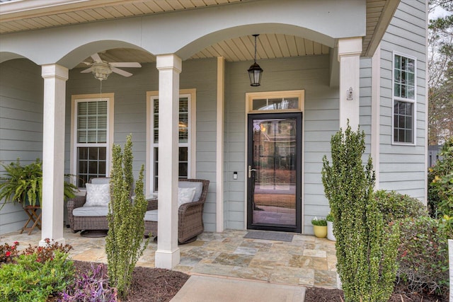 view of exterior entry featuring ceiling fan and a porch