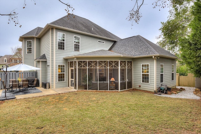 back of property featuring a lawn, a sunroom, and a patio