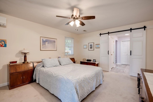 carpeted bedroom featuring a wall mounted air conditioner, ceiling fan, and a barn door