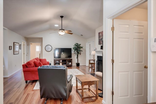 living room with ceiling fan, light wood-type flooring, and lofted ceiling