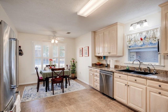 kitchen featuring ceiling fan, sink, stainless steel appliances, and a textured ceiling