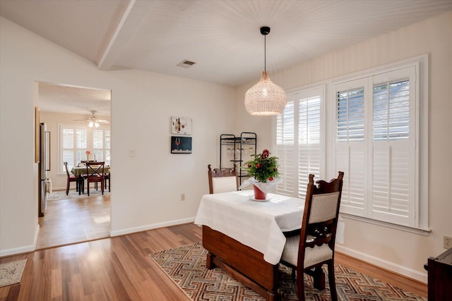 dining space featuring ceiling fan, beam ceiling, a healthy amount of sunlight, and light hardwood / wood-style flooring