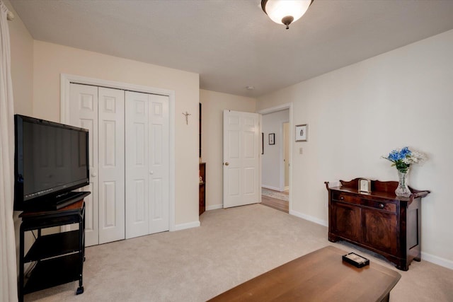 interior space with a textured ceiling, light carpet, and a closet