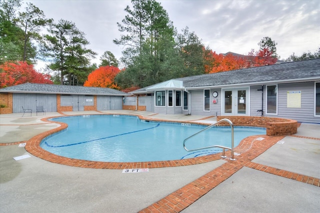 view of swimming pool featuring a patio area and french doors